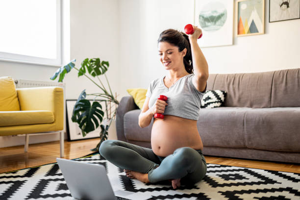 Pregnant woman is doing workout at home