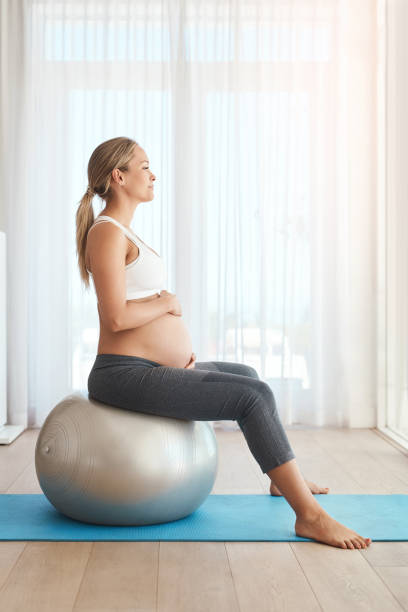 Woman is doing yoga with ball