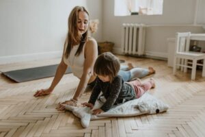 A woman is doing yoga with her kid