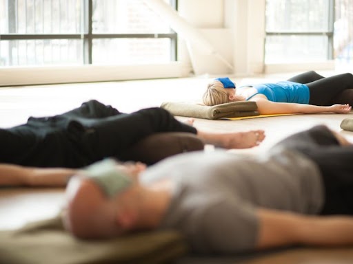 men and women lie down on mat